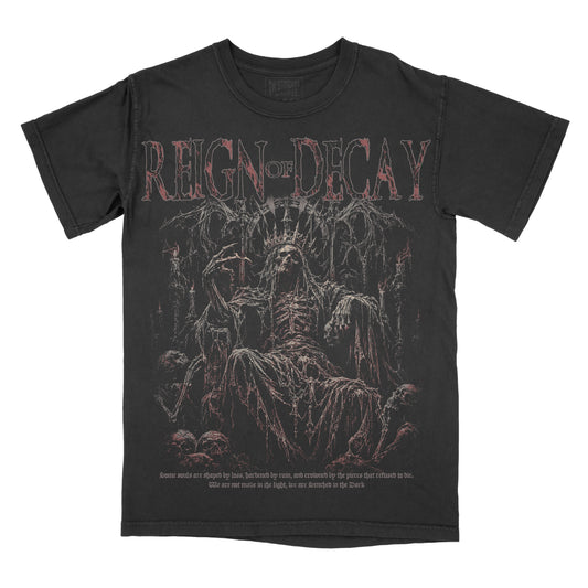 Black vintage-wash graphic tee featuring “Reign of Decay” across the chest above a skeletal crowned figure seated on a gothic throne, surrounded by skulls and distressed dark red details.