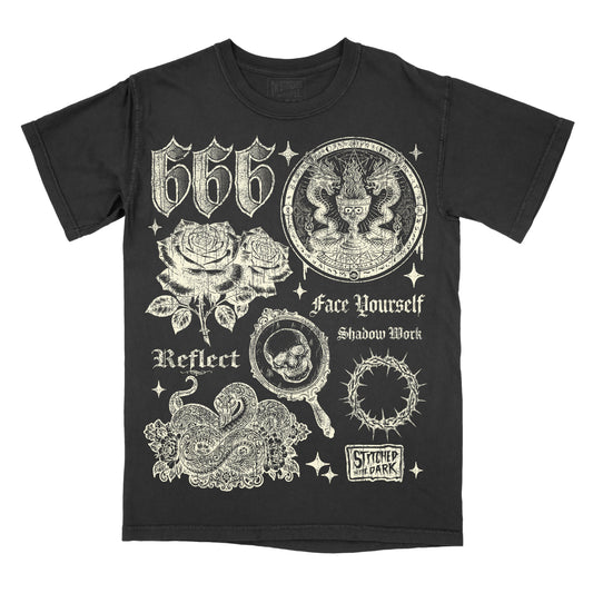 black T-shirt featuring a distressed 666 angel number design with roses, snakes, skulls, a thorn halo, and occult-inspired imagery, with text reading “Face Yourself,” “Shadow Work,” and “Reflect,” plus Stitched in the Dark branding.