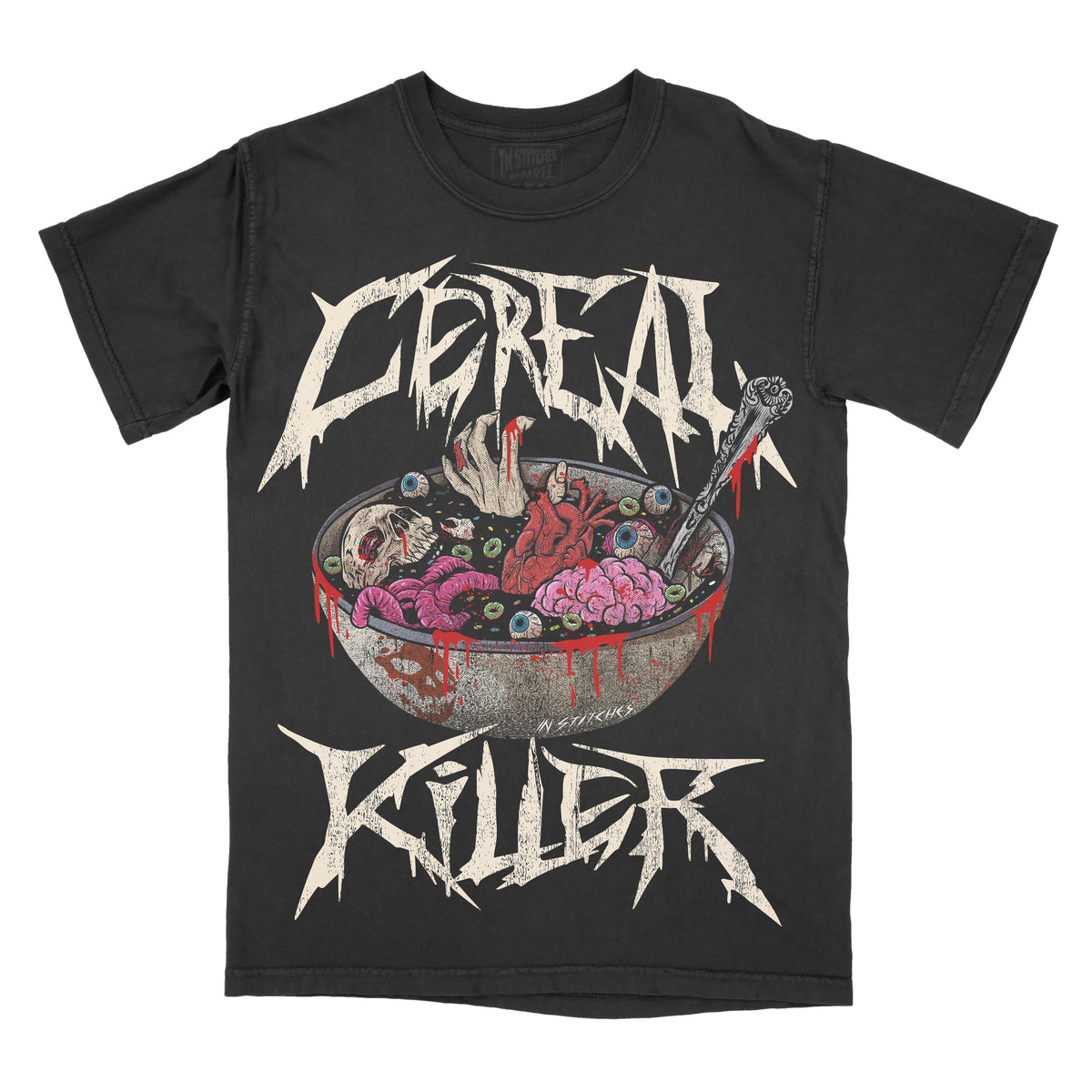 Black graphic t-shirt featuring the phrase “Cereal Killer” in jagged, horror-style lettering above and below an illustration of a cereal bowl filled with eyeballs, brains, and bloody details, with a spoon dripping red liquid.