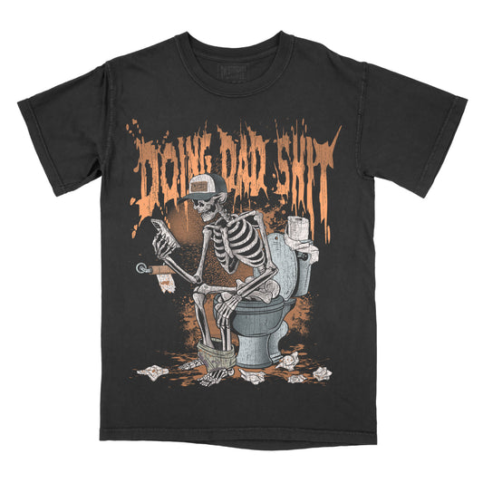 Black graphic tee with a design featuring a skeleton sitting on a toilet with a cup in its hand, and text above the skeleton reading 'DOING DAD SHIT'.