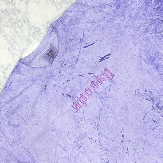 Light purple mineral-washed short-sleeve T-shirt laid flat, featuring small tonal embroidered text reading “spooky” on the chest.