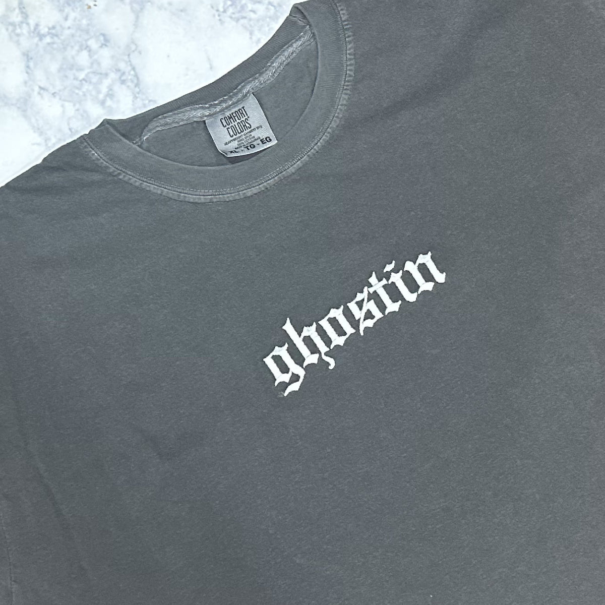 A gpepper embroidered t-shirt with the word 'GHOSTIN' in white thread on the front.