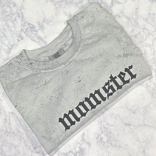 A Smoke Comfort Colors t-shirt with the word 'momster' embroidered in a stylized font.