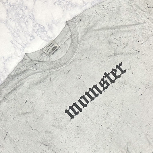 A Smoke Comfort Colors t-shirt with the word 'momster' embroidered in a stylized font.