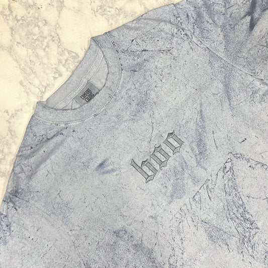 Light blue mineral-washed short-sleeve T-shirt laid flat, featuring small tonal embroidered text reading “boo” on the chest.