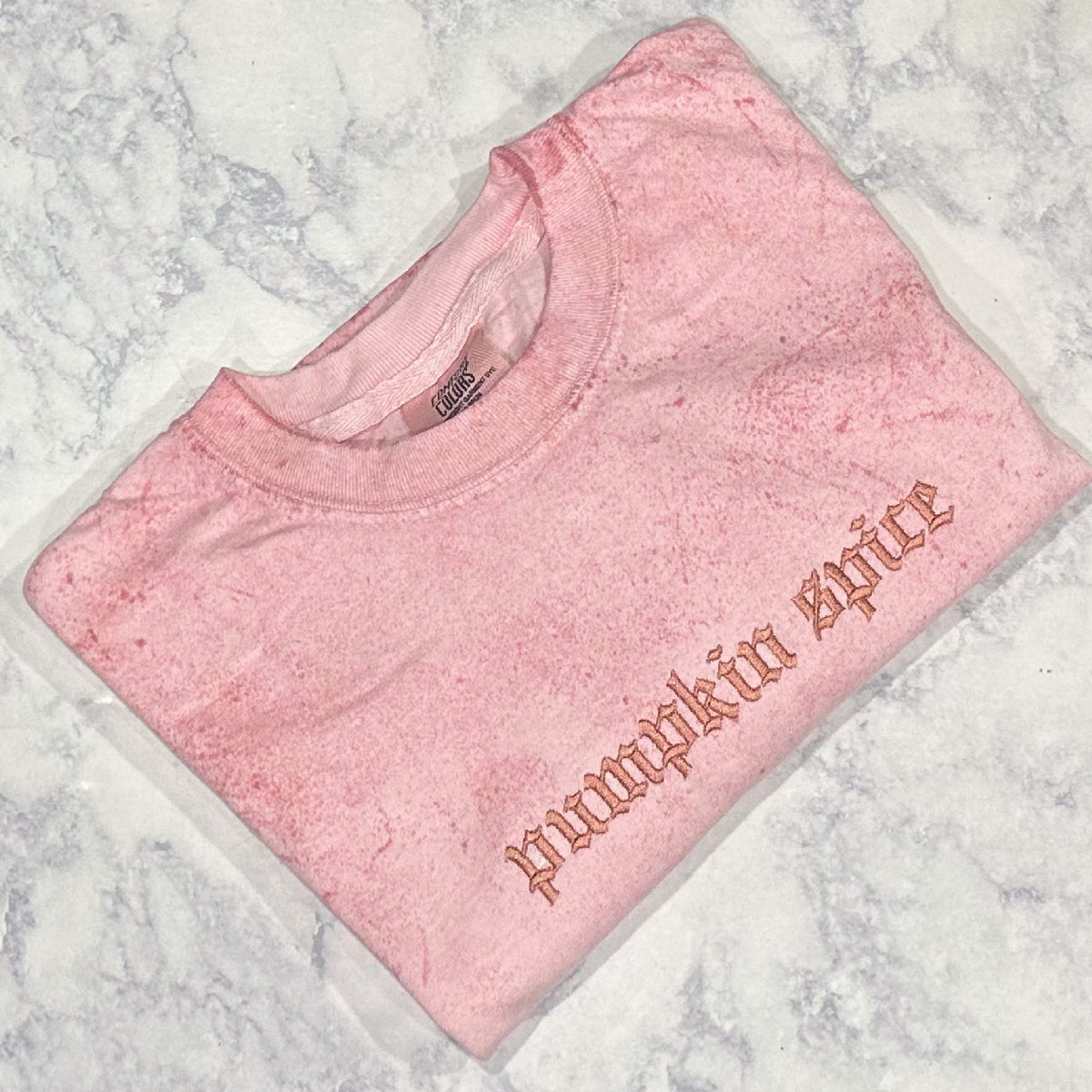 Light pink mineral-washed sweatshirt with monochromatic pink embroidery reading pumpkin spice.