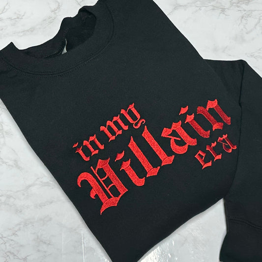 Black crewneck sweatshirt with red embroidered text reading ‘in my villain era.