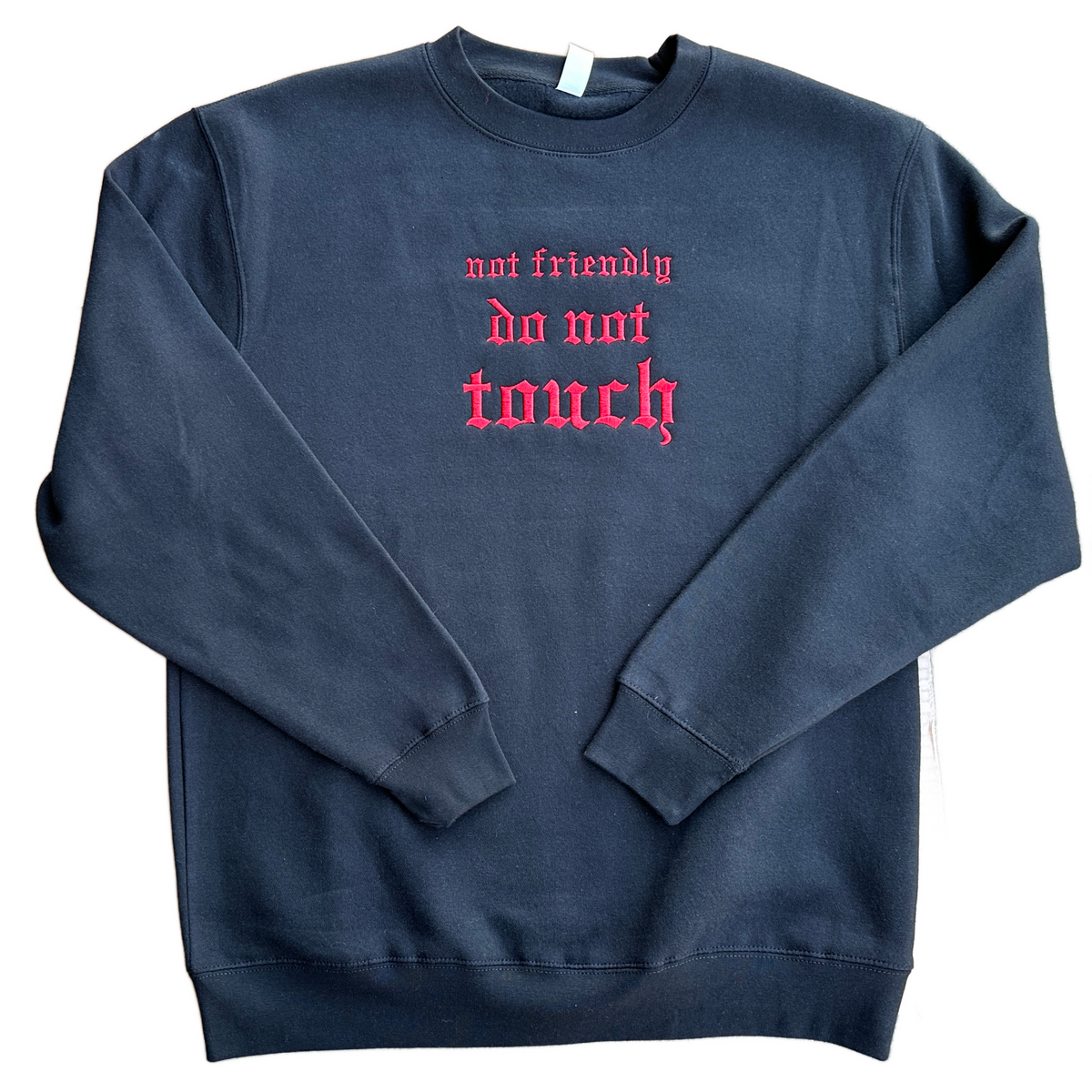 Black crewneck sweatshirt featuring bright red Old English embroidery that reads “not friendly do not touch” across the chest, with a classic round neckline, long sleeves, and ribbed cuffs and hem.