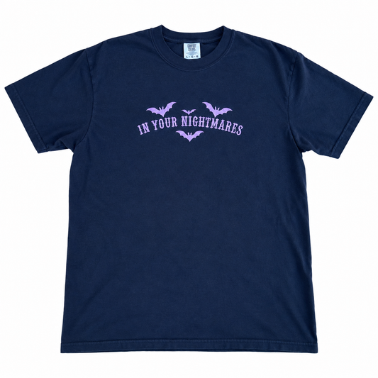 black Comfort Colors T-shirt featuring lavender embroidered gothic text reading “In Your Nightmares,” surrounded by four embroidered bats, styled on a white  background.
