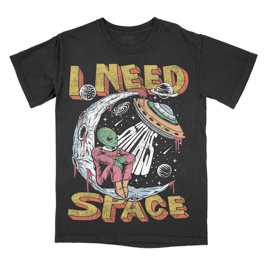 A black graphic tee with a design that includes a stylized alien and the text 'I NEED SPACE' on the front.