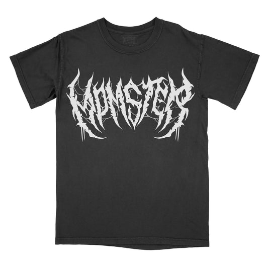 Black T-shirt featuring the word "MOMSTER" in a white heavy metal-inspired font with sharp, jagged lettering, subtle spiderweb details, and dripping accents.