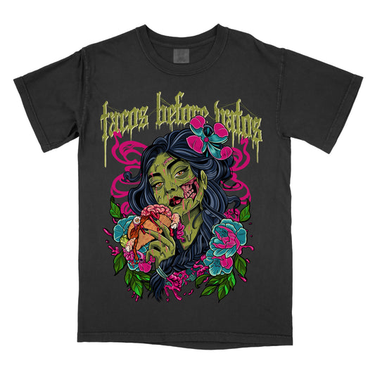 Black t-shirt with the phrase ‘Tacos Before Vatos’ above a colorful gothic illustration of a woman holding a taco surrounded by flowers