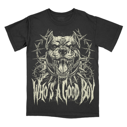 A black short-sleeve graphic t-shirt featuring a distressed cream print of a snarling pit bull surrounded by barbed wire, with the text 'WHO'S A GOOD BOY' in a jagged metal-style font below.