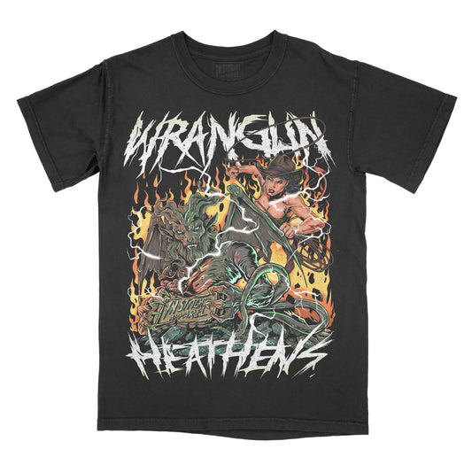 Black graphic t-shirt featuring the phrase “Wranglin’ Heathens” in jagged lettering above and below a fiery illustration of a cowgirl fighting a horned creature with flames and western horror details.