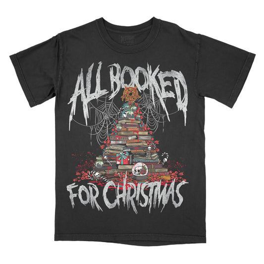 Black graphic tee with a Christmas-themed design featuring a tree made out of books, decorations, and the text 'All Booked For Christmas'.