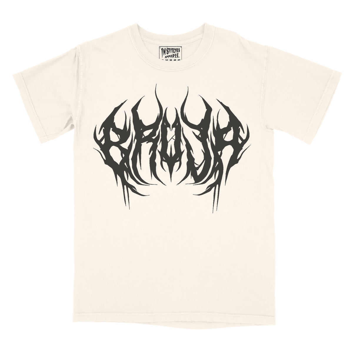 Cream graphic tee with 'Bruja' text in a stylized font and a graphic design in black.