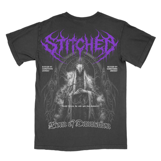 Back of a black vintage-wash Born of Damnation graphic tee featuring a large dark gothic figure framed by cathedral-inspired details, purple Stitched lettering, “Blessed by Something Unholy” text, and “Born of Damnation” across the bottom.