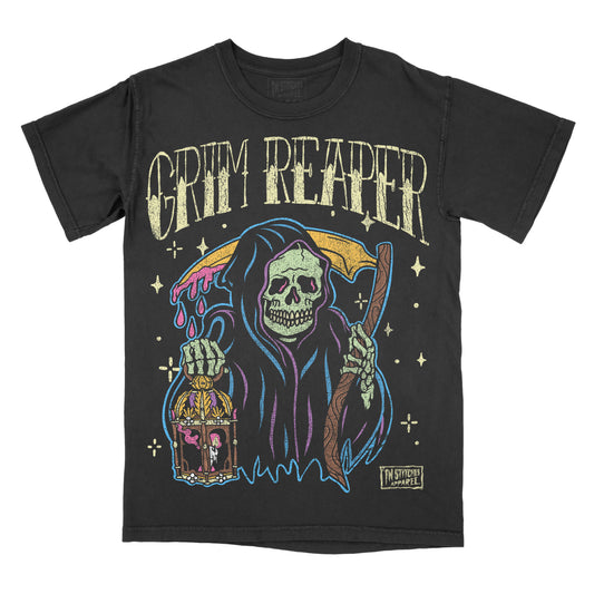 A black short-sleeve graphic t-shirt featuring a stylized Grim Reaper design with the words 'GRIM REAPER' in distressed cream lettering above. The graphic depicts the hooded Reaper holding a scythe and a birdcage, with colorful neon-like accents in blue, pink, and yellow on a plain white background.