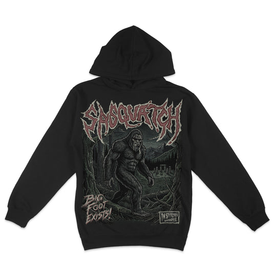 Black hoodie featuring a vintage Sasquatch Bigfoot graphic with distressed red lettering and a dark forest and mountain scene.