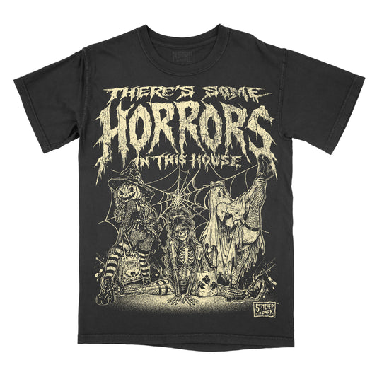 Black vintage wash T-shirt featuring three spooky girls in witch, skeleton, and ghost costumes with spiderwebs and the phrase “There’s Some Horrors in This House.”