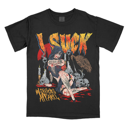 Black t-shirt featuring a horror-inspired illustration of a seated woman surrounded by candles and skulls, with the words ‘I Suck’ in distressed lettering and a vampire-themed gothic design.