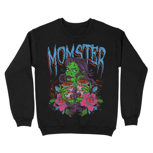 Black sweatshirt with a large print of a green monster character, surrounded by pink and purple floral designs, with the word 'MOMSTER' written across the chest in bold, blue letters.