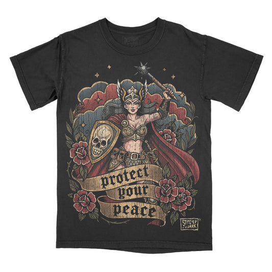 T-shirt featuring a distressed tattoo-style warrior woman holding a spiked mace and skull shield, surrounded by red roses, with a banner reading “Protect Your Peace” and Stitched in the Dark branding.