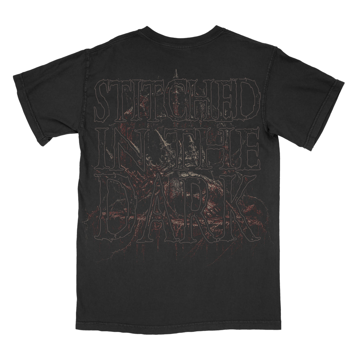 Back of a black vintage-wash graphic tee featuring oversized distressed “Stitched in the Dark” lettering layered over a dark skeletal figure with muted red gothic details.