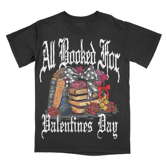 Black graphic tee with 'All Booked For Valentine's Day' text and book-themed illustrations including a bow, flowers, and a shelf of books.